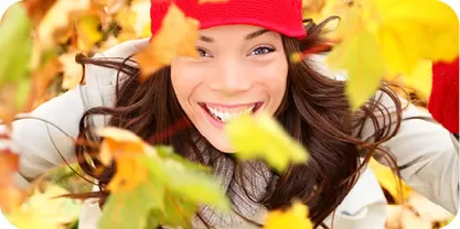 Fall scene with leaves and woman smiling 