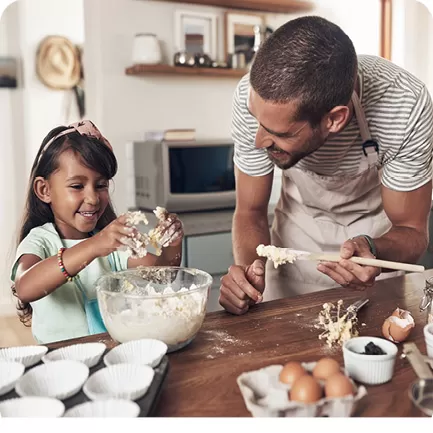 Father and Daughter baking cookies in a light airy kitchen